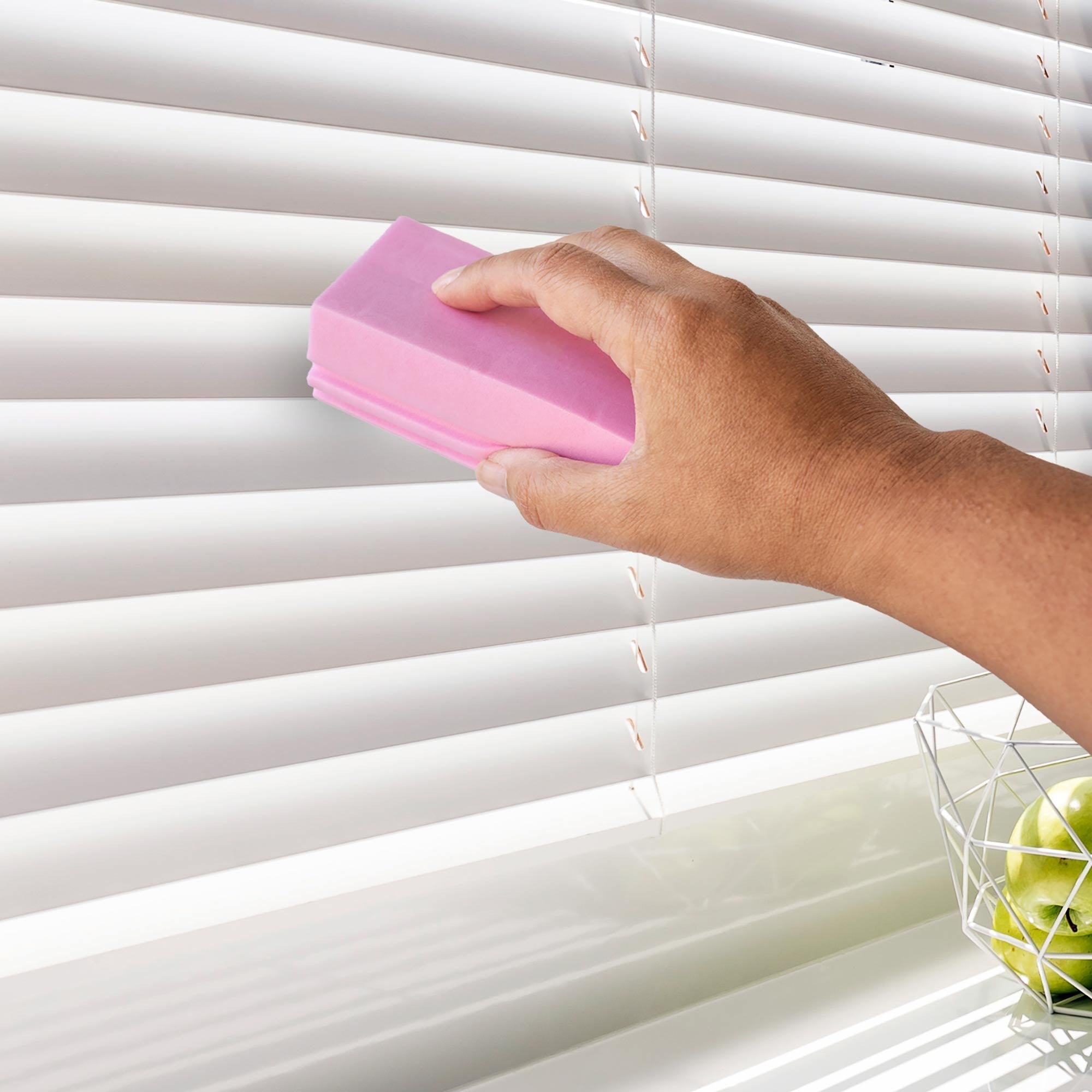 Hand using a pink cleaning tool to clean white window blinds. Simply Clean Damp Duster Sponge - 2 Pack