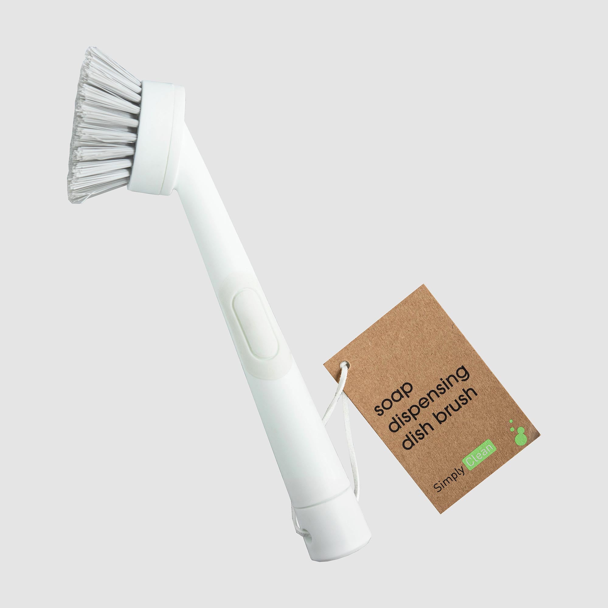 White soap dispensing dish brush with a brown tag on a light gray background. Simply Clean Scrub Brush - White