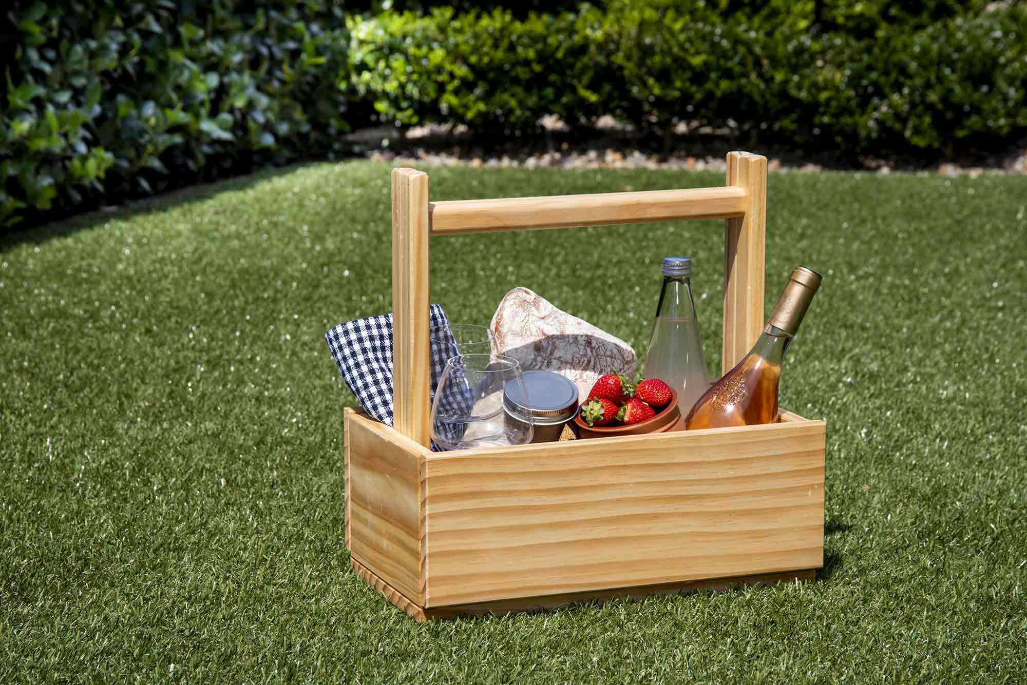 Wooden picnic basket with food and drinks on a grassy area. Victoria James Home Storage Box VJA Convertible