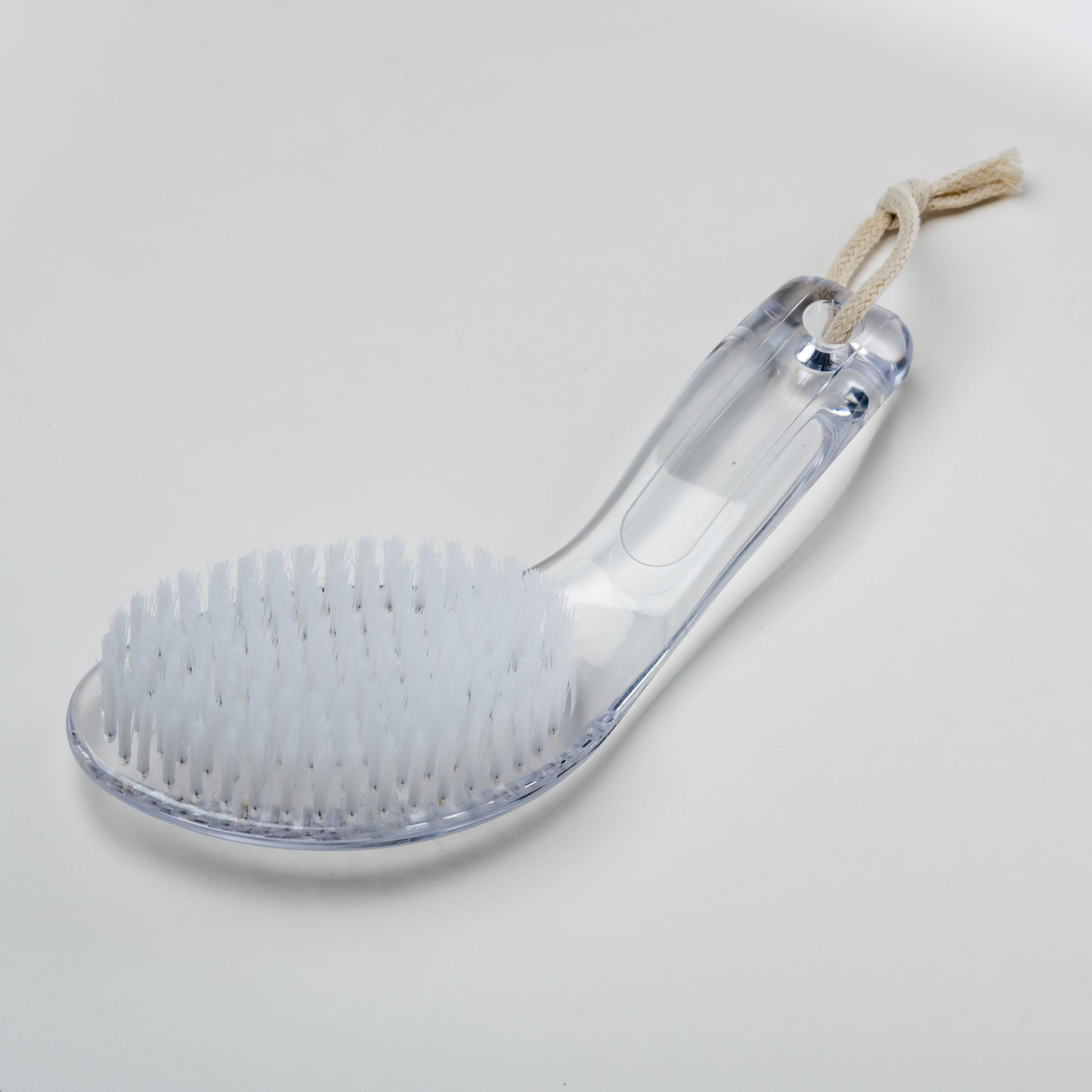 Clear grooming brush with bristles on a light gray background. Victoria James Body Bath & Shower Brush