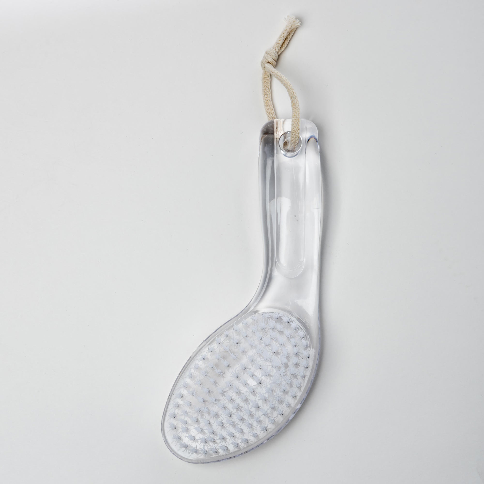 Clear glass boot with textured sole on a white background. Victoria James Body Bath & Shower Brush