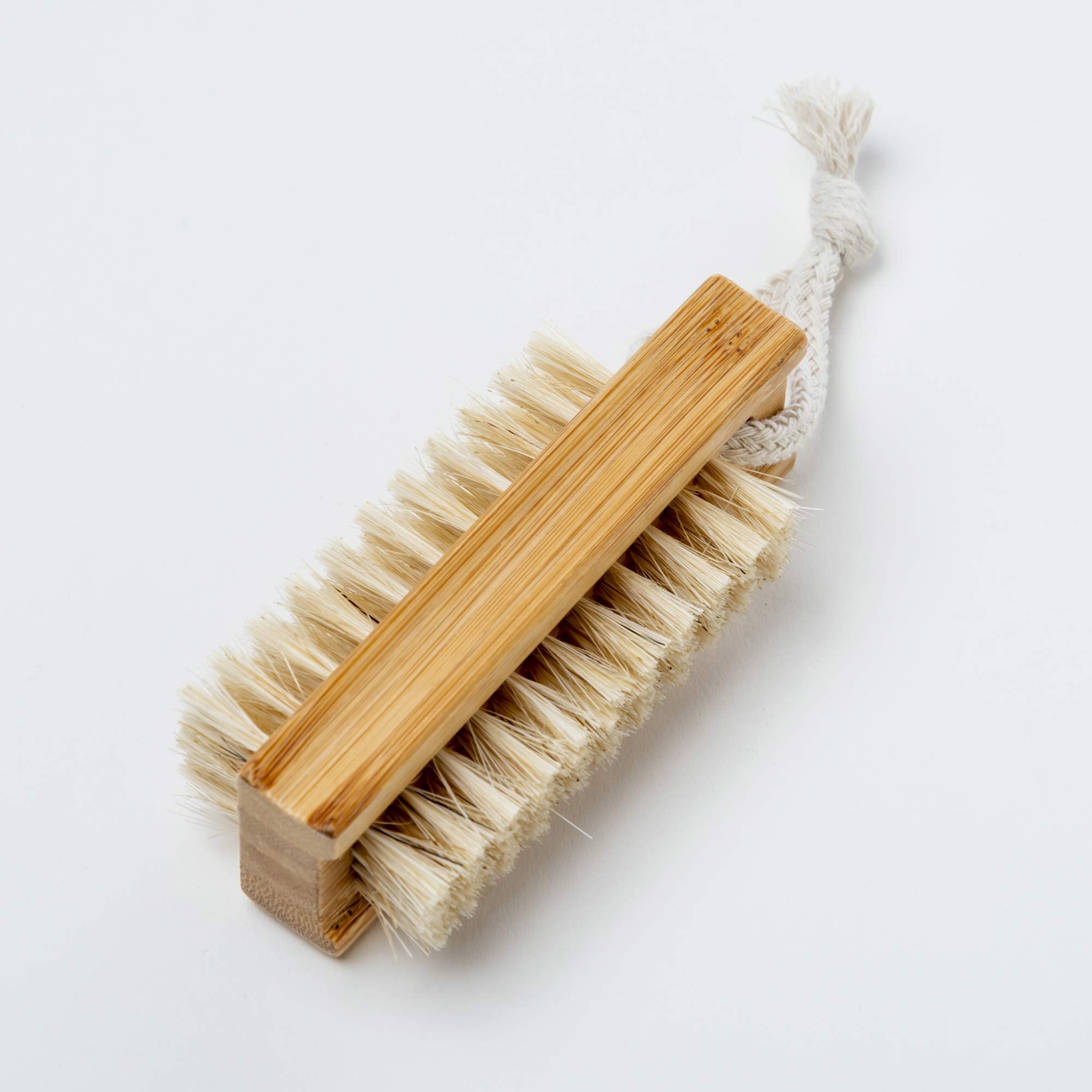 Barefoot brush with wooden handle and natural bristles on a white background. Victoria James Body Nail Brush